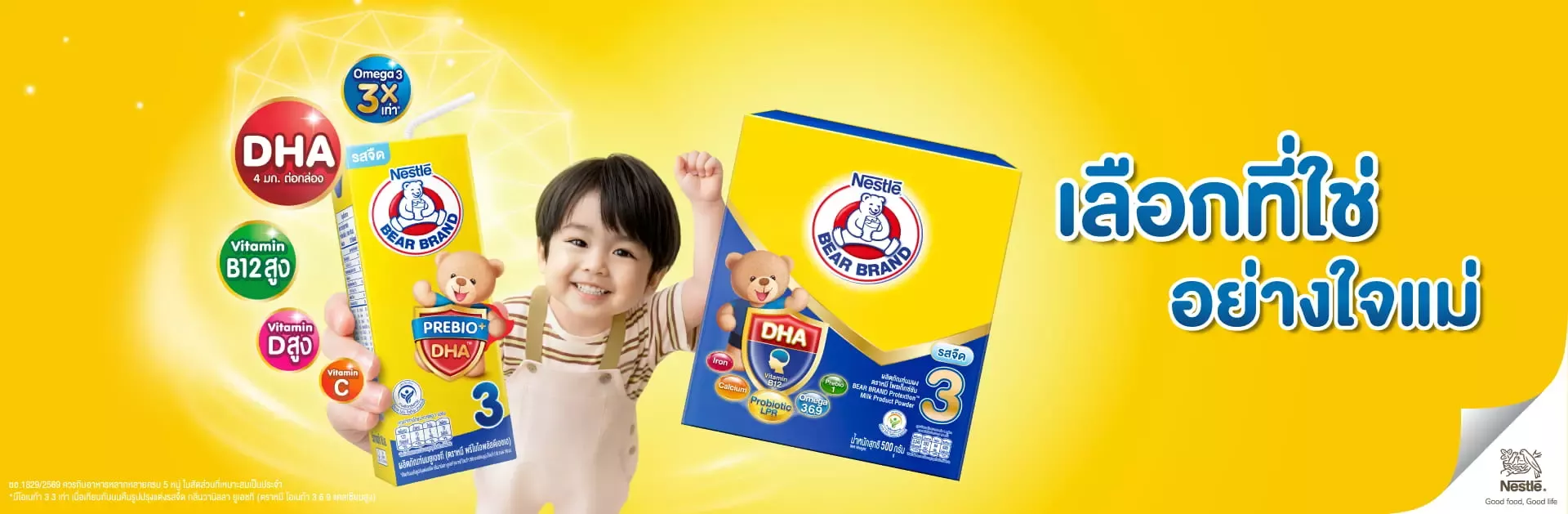 เด็กชายยิ้มสดใสถือกล่องนมยูเอชทีตราหมี พรีไบโอพลัสดีเอชเอ คู่กับกล่องนมผงตราหมี บนพื้นสีเหลือง​
